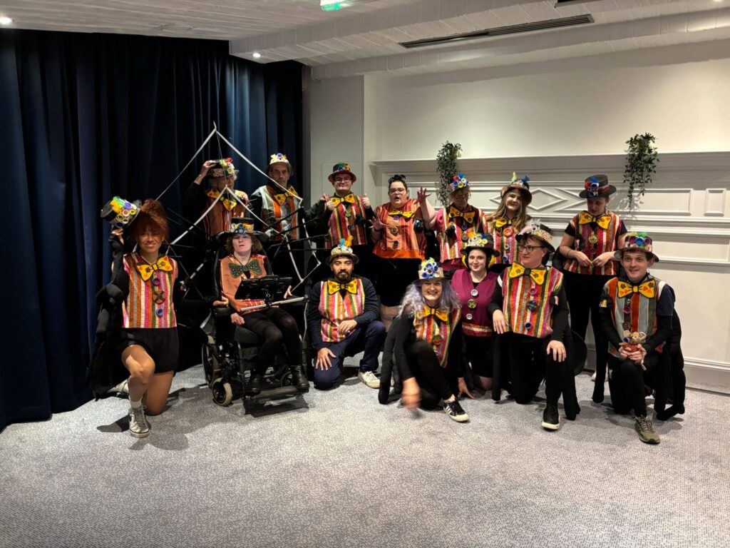 A group photo of men and women dressed in costume for a dance troupe parade